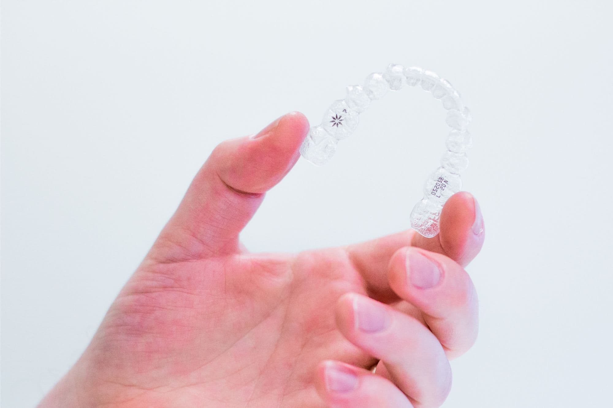 Clear Invisalign aligner being held, representing orthodontic treatment options available at Wiesemann Orthodontics in Bowling Green, KY.