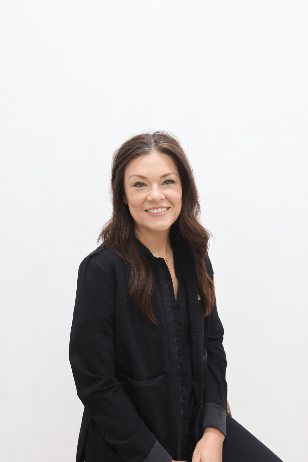 Smiling female orthodontic team member in black attire, representing Wiesemann Orthodontics, showcasing expertise in braces and Invisalign for patients in Russellville and Bowling Green.