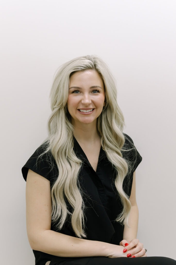 Sydney, Clinical Assistant at Wiesemann Orthodontics, smiling with long blonde hair and a black top, promoting friendly orthodontic care for braces and Invisalign in White House, TN.